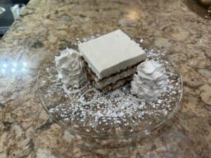 Delicious layered dessert with whipped cream and powdered sugar at Angelo's Restaurant.