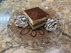 Delicious tiramisu dessert with whipped cream and cocoa powder at Angelo's Restaurant.