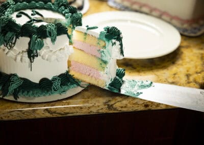 Freshly sliced colorful layered cake with green and white frosting at Angelo's Restaurant. Cake with vibrant layers and decorative frosting, perfect for celebrations at Angelo's Restaurant.