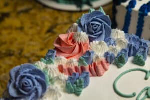 Beautiful birthday cake decorated with blue roses and pastel frosting.