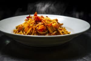 Delicious steaming spaghetti with fresh tomato sauce and herbs.