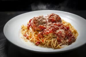 Delicious spaghetti topped with savory meatballs and rich tomato sauce, served with grated Parmesan.