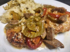 Delicious grilled chicken with sautéed peppers and sausage, served with creamy mashed potatoes. Perf.