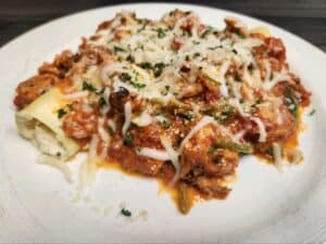Classic Chicken Parmesan with melted cheese and herbs, served on a white plate.
