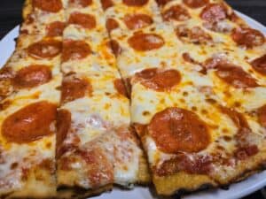 Delicious pepperoni pizza slice with melted cheese and crispy crust at Angelo's Restaurant.
