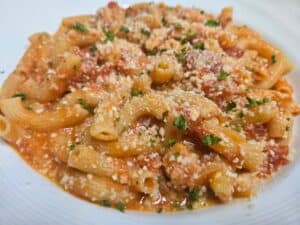 Delicious pasta with tomato sauce, herbs, and grated cheese, served at Angelo's Restaurant.