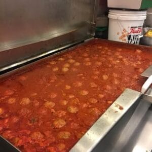 Delicious meatballs simmering in rich marinara sauce at Angelo's Restaurant.