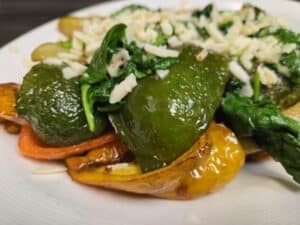 Stuffed peppers with cheese, greens, and vegetables, served at Angelo's Restaurant.