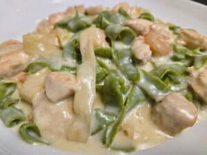 Creamy chicken and green pasta dish at Angelo's Restaurant, featuring tender chicken, fresh green pa.