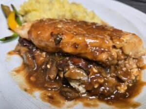 Delicious grilled fish topped with savory mushroom sauce, served with mashed potatoes.