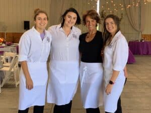 Staff at Angelo's Restaurant in uniform, smiling in a bright, elegant dining space.