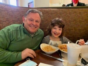 Family enjoying meal at Angelo's Restaurant with pasta and fries.