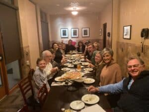 Family dinner at Angelo's Restaurant with friends enjoying pizza and drinks.