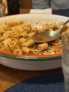 Delicious rigatoni pasta with tomato sauce served in a colorful bowl at Angelo's Restaurant.