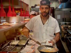 Chef preparing a dish in Angelo's Restaurant kitchen.